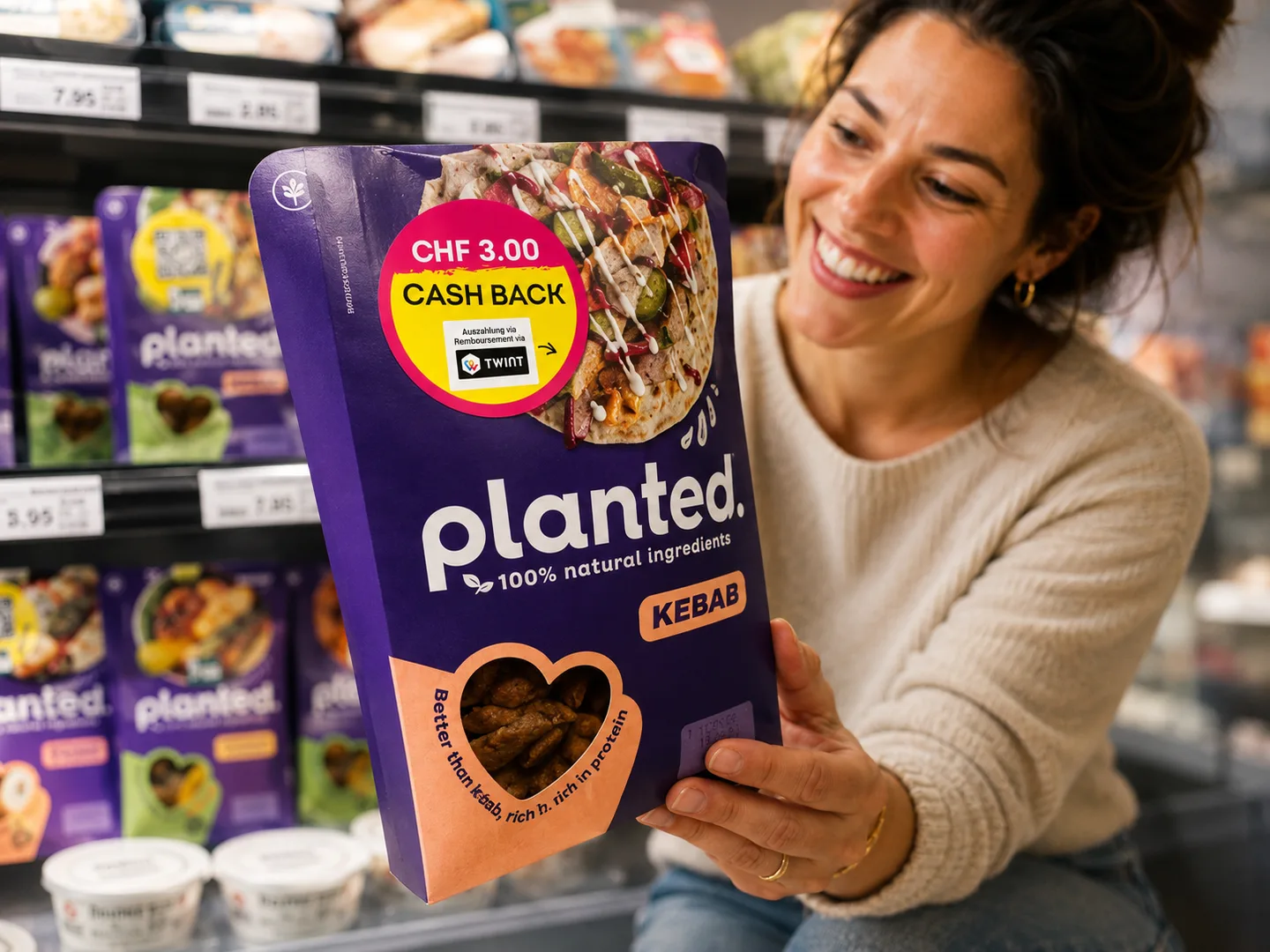 Eine Kundin hält im Regal eine planted Kebab-Packung mit einem CHF 3.00 TWINT Cashback-Sticker.